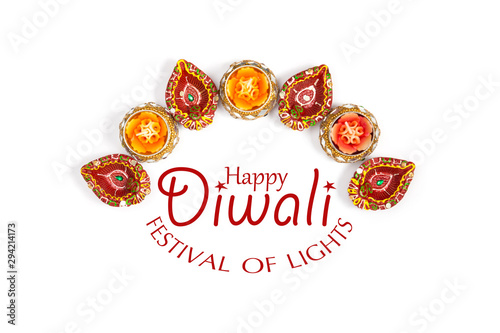 Happy Diwali - Clay Diya lamps lit during Dipavali, Hindu festival of lights celebration. Colorful traditional oil lamp diya on white background. Copy space for text.