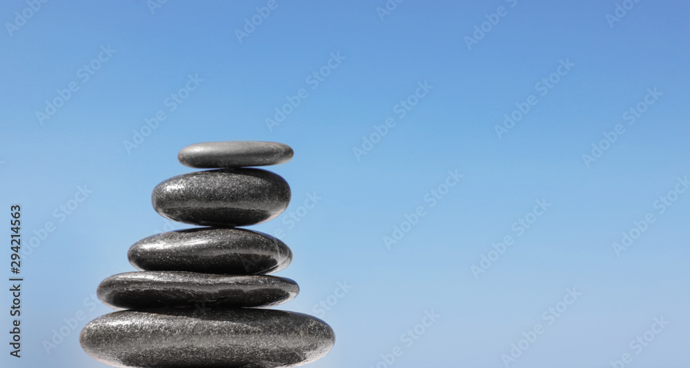 Stack of stones against blue sky, space for text. Zen concept Stack of stones against blue sky, space for text. Zen concept