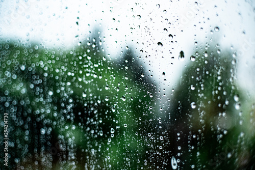 raindrops on the glass outside the window cloudy sky and greenery