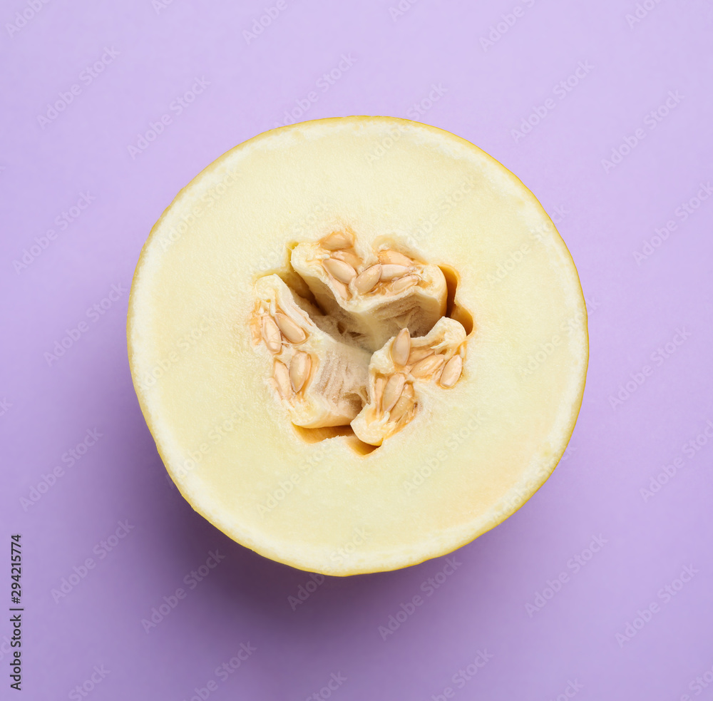 Half of ripe tasty melon on violet background, top view
