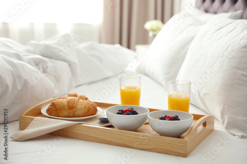 Dienblad met lekker ontbijt op bed in lichte kamer