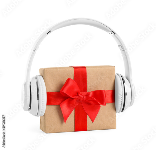 Gift box with headphones isolated on white. Christmas music concept