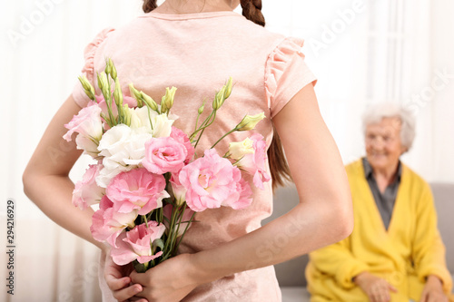 Girl congratulating her grandmother at home, closeup photo