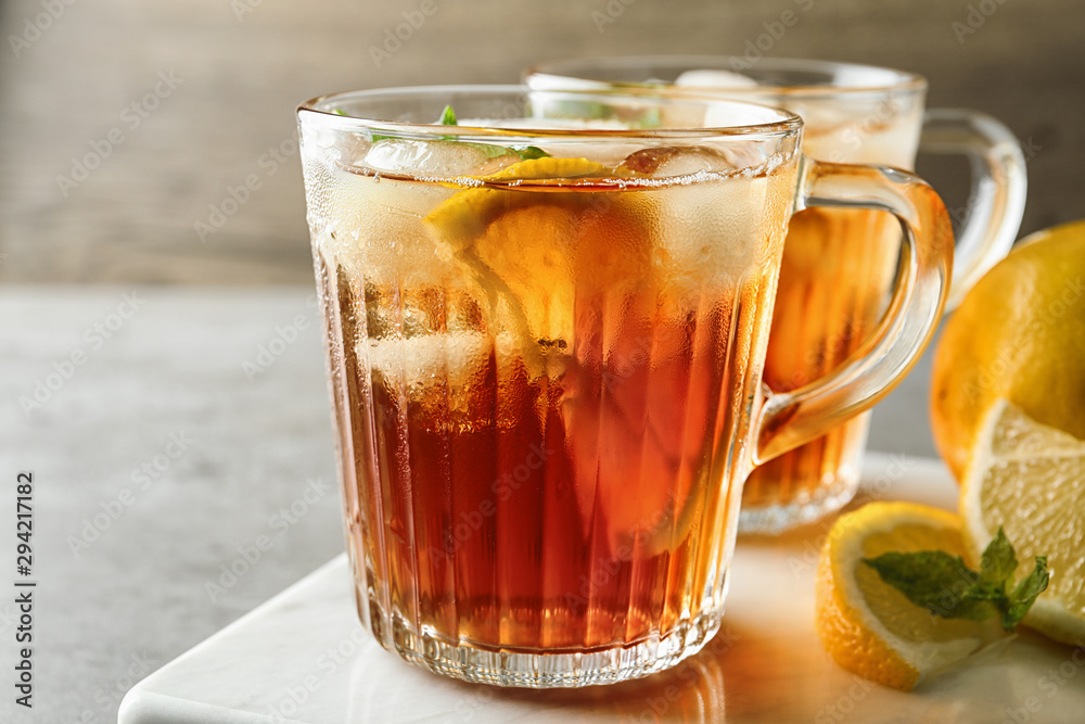 Cups of refreshing iced tea on table against wooden background Cups of refreshing iced tea on table against wooden background