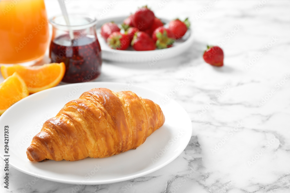 Tasty breakfast with croissant served on white marble table