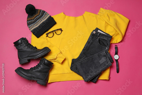 Flat lay composition with winter clothes and boots on pink background