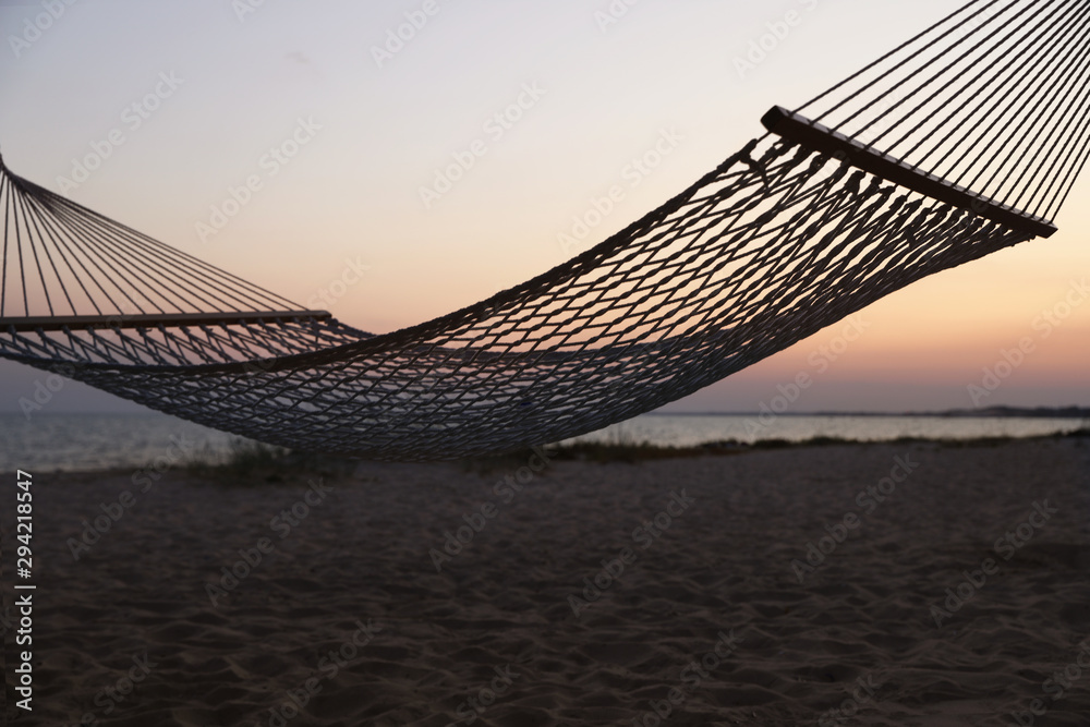 Obraz premium Empty hammock on beach at sunset. Time to relax
