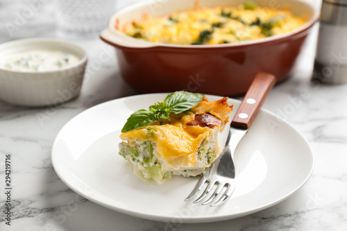 Piece of tasty broccoli casserole on white marble table