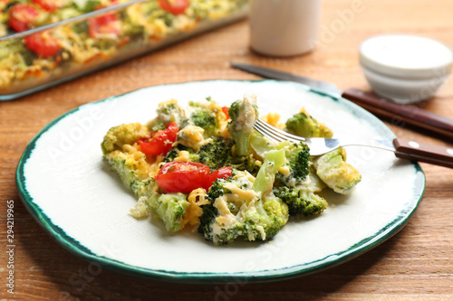 Tasty broccoli casserole served on wooden table