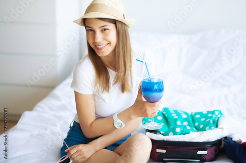 Vacation. Woman Who is Preparing for Rest. Young Beautiful Girl Sits on the Bed. Portrait of a Smiling Woman. Happy Girl Goes On Vacation