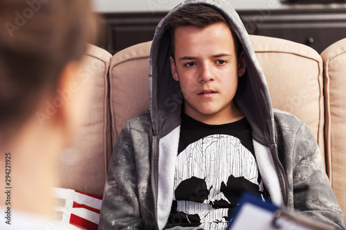 Teenager boy sitting at counseling - in front of the therapy professional, close up