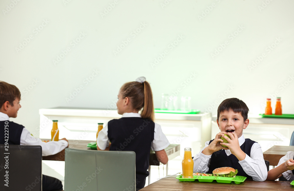Happy children eating healthy food for lunch in school canteen Happy children eating healthy food for lunch in school canteen