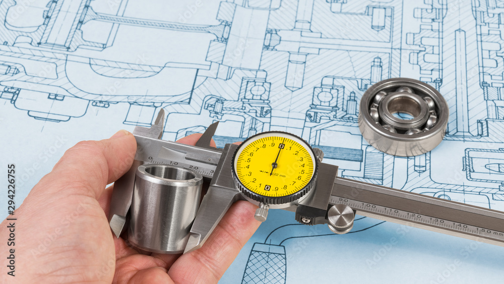 Steel part measurement by caliper in human hand. Ball bearing on