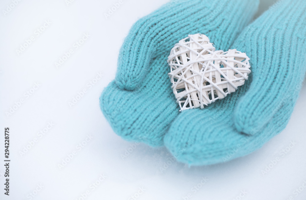 Female hands in mittens with heart, close-up Female hands in mittens with heart, close-up