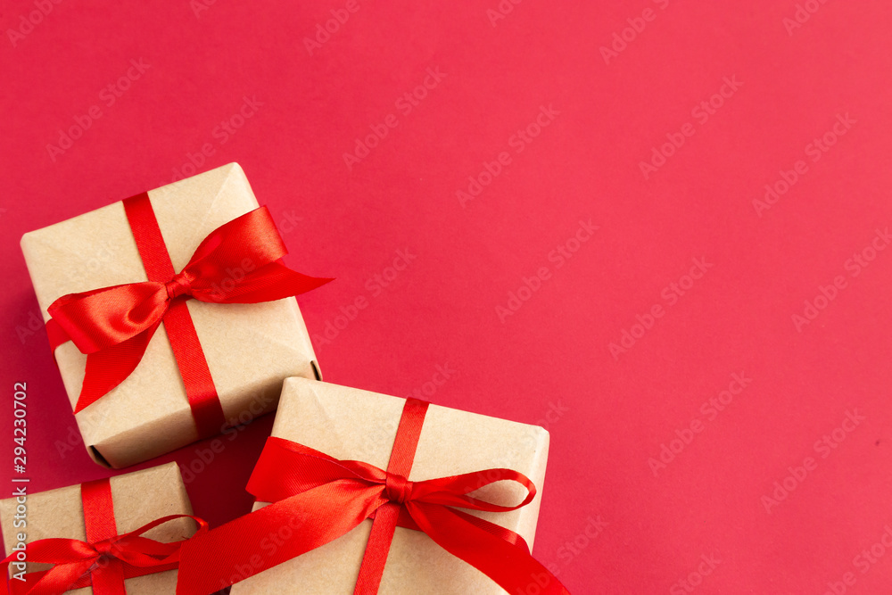 brown gift box with red ribbon on red background top view for christmas or celebrate brown gift box with red ribbon on red background top view for christmas or celebrate