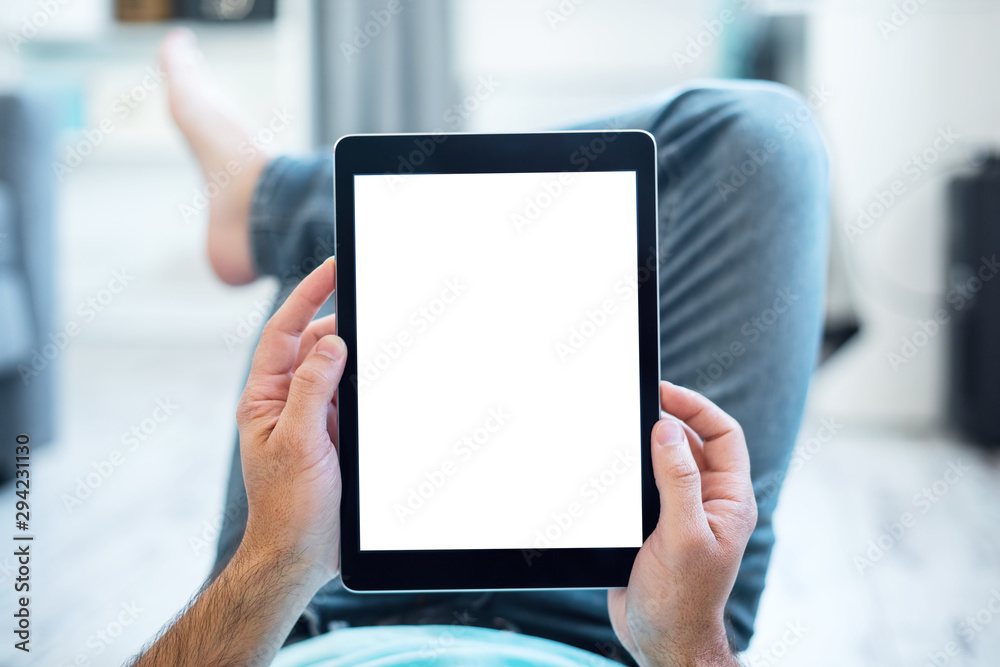 Mockup of a Man Using Tablet PC While Lying on a Floor. Clipping path included.