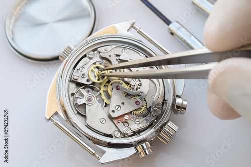 close up macro pic of vintage chronograph watch mechanism under repair by watchmaker
