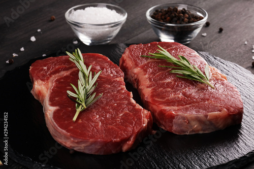 Steak raw. Barbecue Rib Eye Steak or rump steak on dark rustic table photo