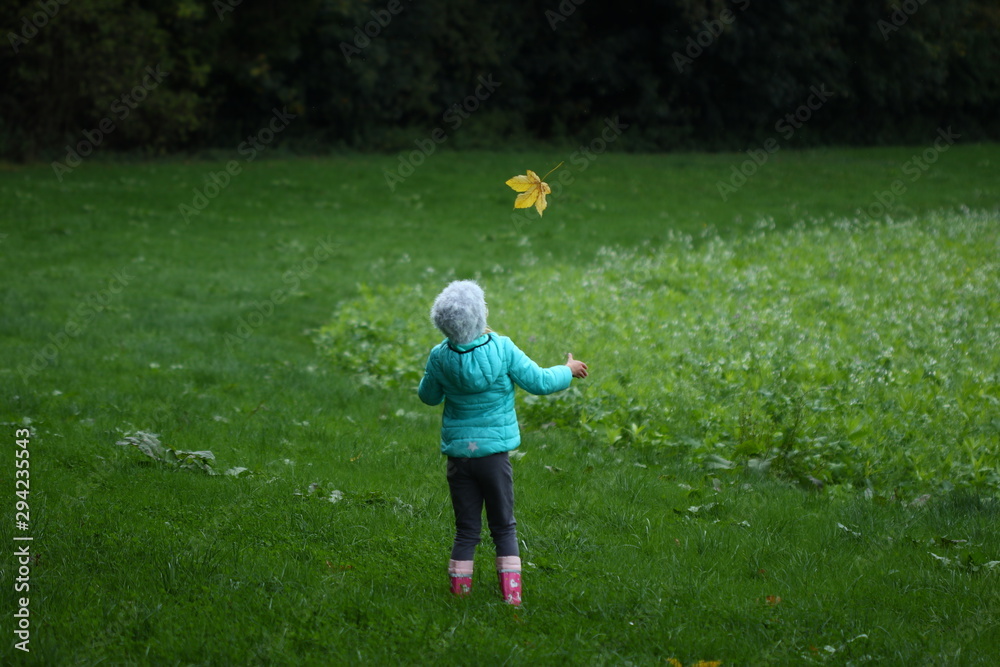 junges Mädchen wirft ein Herbstblatt in die Luft junges Mädchen wirft ein Herbstblatt in die Luft