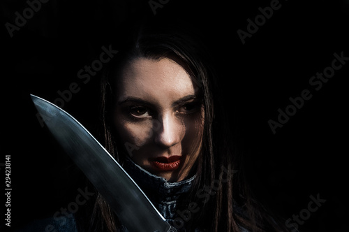 Valokuva Beautiful smiling  brunette  girl attacs with a big scary shiny knife