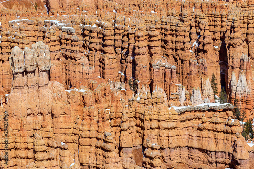 A full frame photograph of red rock formations in Bryce Canyon, during winter