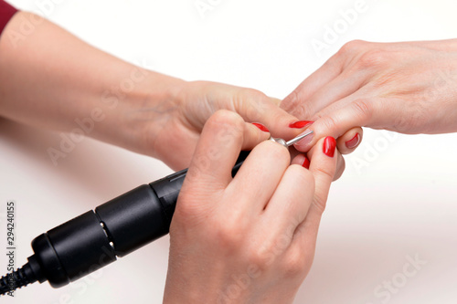 Cuticle processing with a milling machine. Session hardware manicure in the spa salon. Manicure closeup shot. Cleansing cuticle on female nails in a beauty salon.