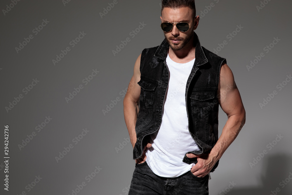 Tough man posing with both hands in his pockets Tough man posing with both hands in his pockets