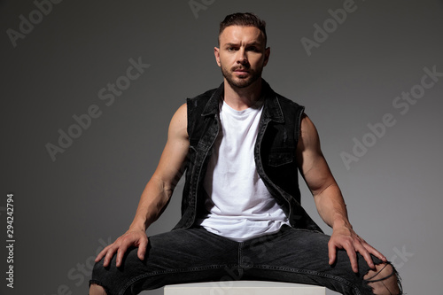 Handsome man sitting with his legs apart