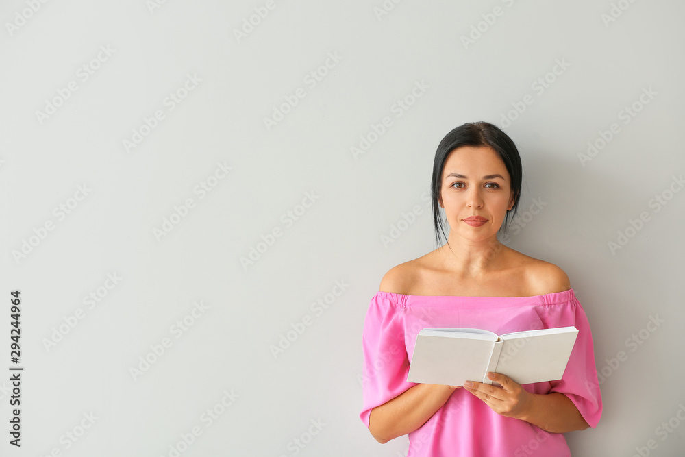 Portrait of beautiful woman reading book on light background Portrait of beautiful woman reading book on light background