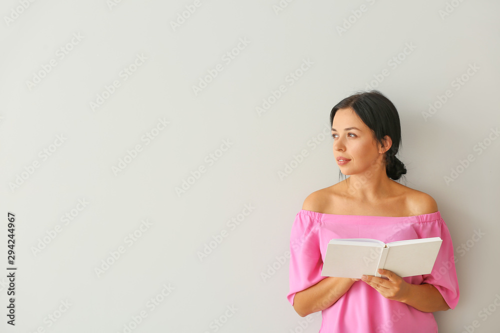 Portrait of beautiful woman reading book on light background Portrait of beautiful woman reading book on light background