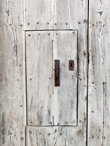 Old wooden rustic wall with small door. © volgariver