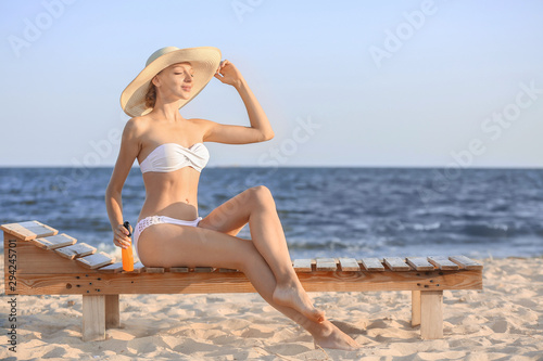 Wallpaper Mural Beautiful young woman with sun protection cream on sea beach Torontodigital.ca