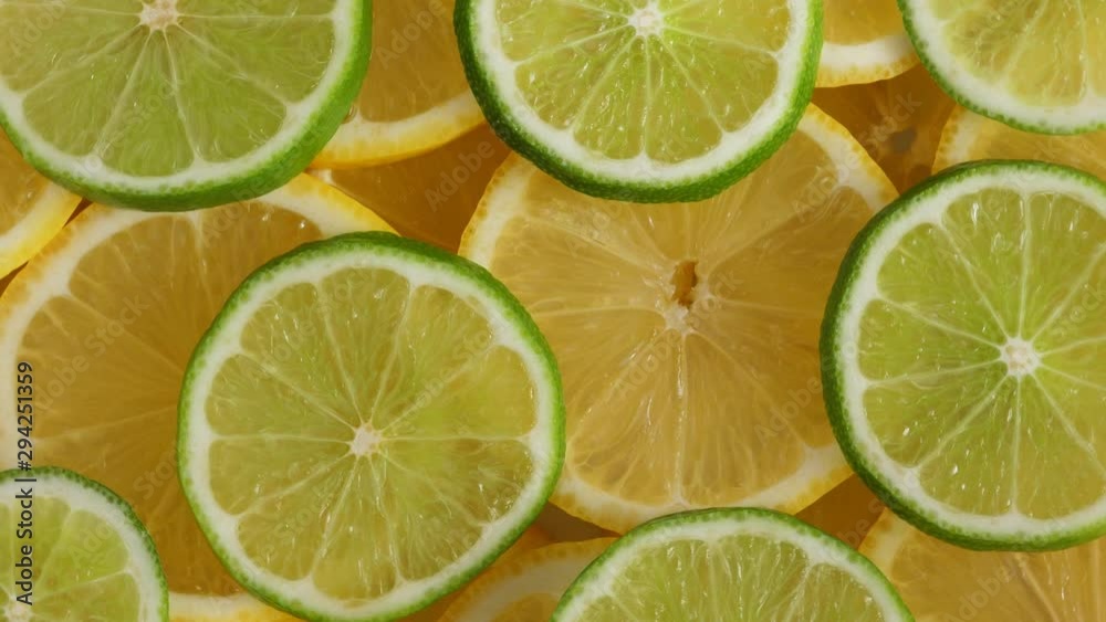 Lemon slices with one cut lime slice closeup, food summer background, top view. Rotate Lemon slices with one cut lime slice closeup, food summer background, top view. Rotate