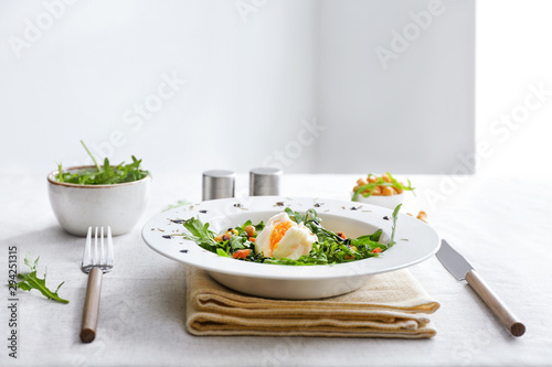 Plate with tasty salad on table