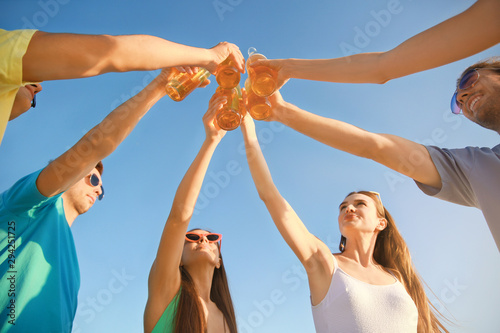 Happy friends drinking beer outdoors