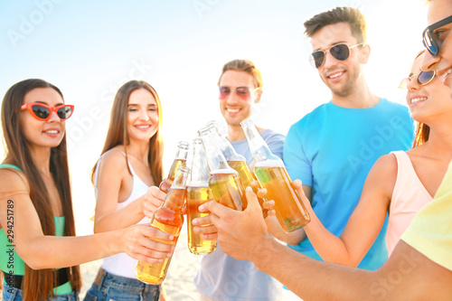 Friends drinking beer on sea beach