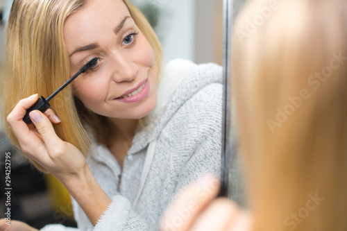 a woman applying a mascara
