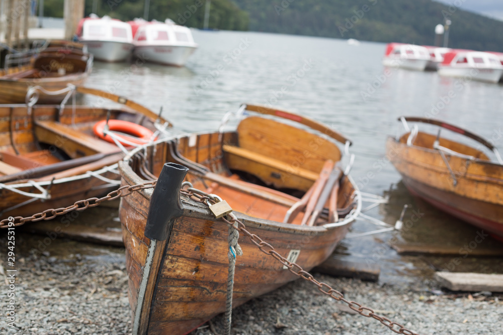 Boats moored on pebble beach on the edge of Lake Windermere 