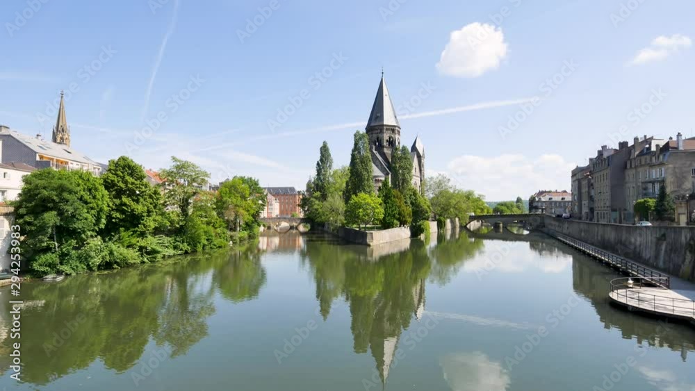 Time lapse of Metz. Cityscape. We can see the iconic Protestant church Temple Neuf on the Moselle river. Reflections, some clouds in the sky. Filmed in the summer. Time lapse of Metz. Cityscape. We can see the iconic Protestant church Temple Neuf on the Moselle river. Reflections, some clouds in the sky. Filmed in the summer.
