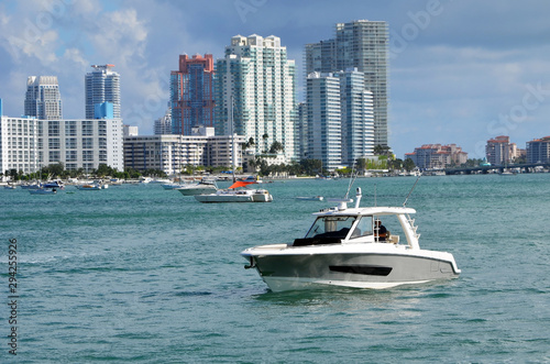 Small cabin cruiser idling on the Florida Intra-Coastal Waterway with Miami Beach condo building skyline in the background © Wimbledon
