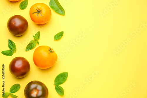 Fototapeta Naklejka Na Ścianę i Meble -  Different fresh tomatoes with basil on color background