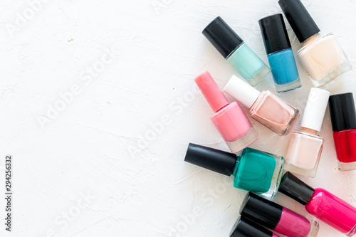Set of colorful nail polish. Polish bottels on white background top view copy space