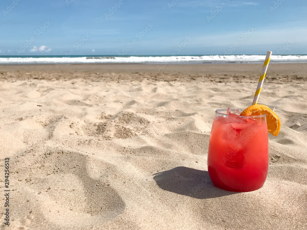glass with red tasty cocktail stands on the beach against the sea 1 glass with red tasty cocktail stands on the beach against the sea 1