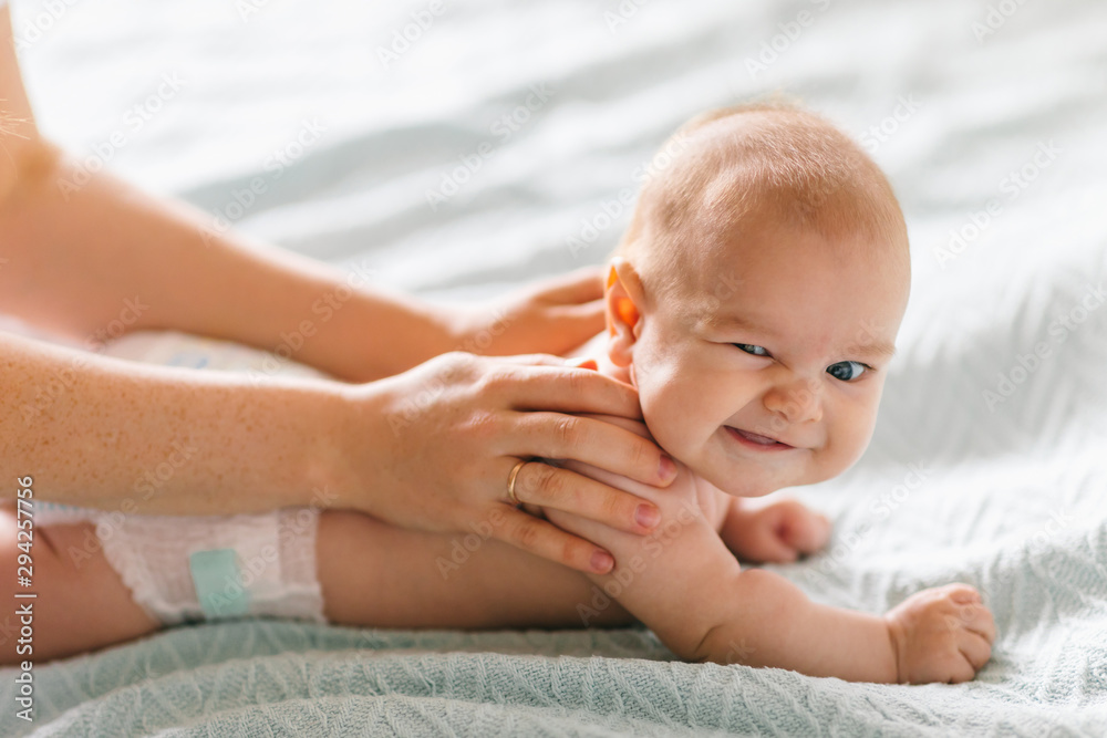 Massage for the baby. Four month old baby smiling doing gymnastics Massage for the baby. Four month old baby smiling doing gymnastics
