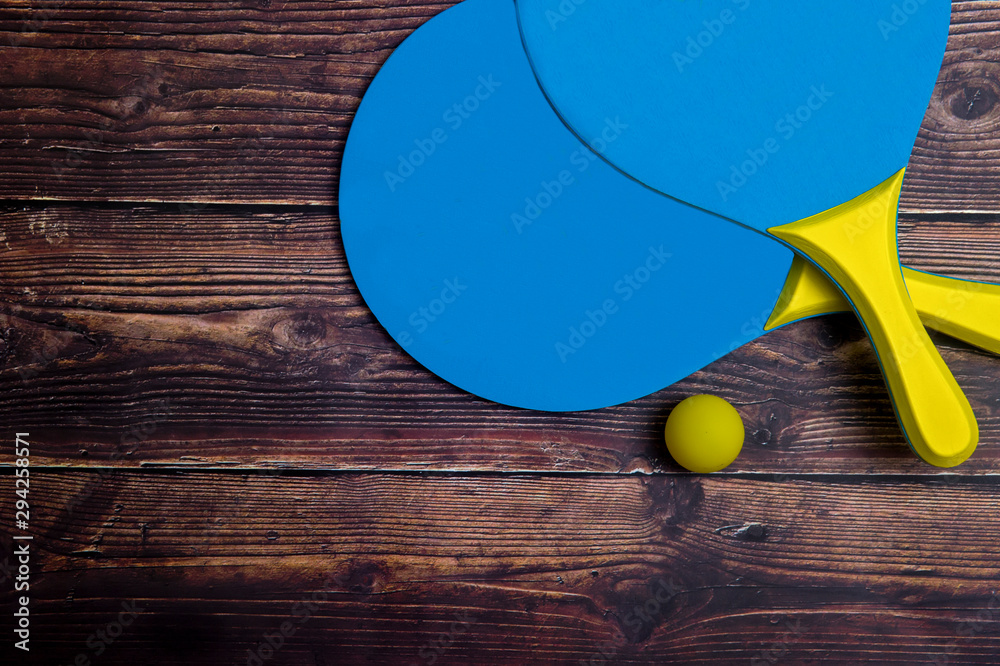Beach Tennis Racket Set. Beach paddle tennis racket set with rubber ball, on a wooden background.