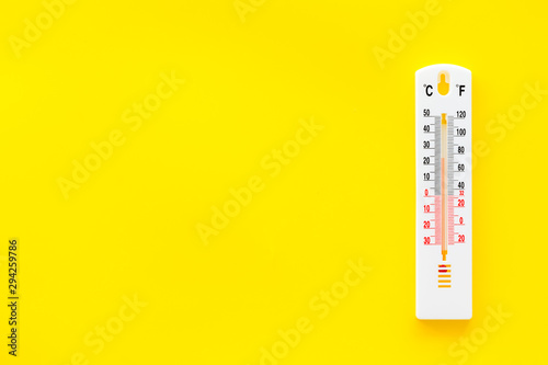 Weather thermometer on yellow background top view copy space