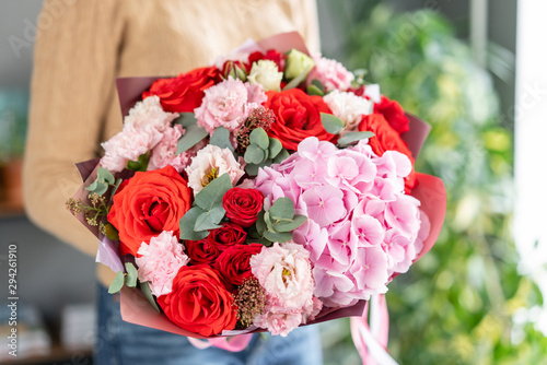 Pink and red color. Beautiful bouquet of mixed flowers in womans hands. the work of the florist at a flower shop. Fresh cut flower.