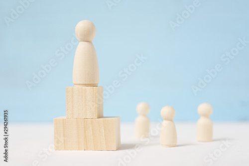 Figure of man on blocks are located as podium and people beside him.