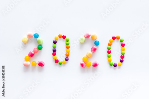 Sweet New Year design. 2020 laid out with candy on white background top view copy space