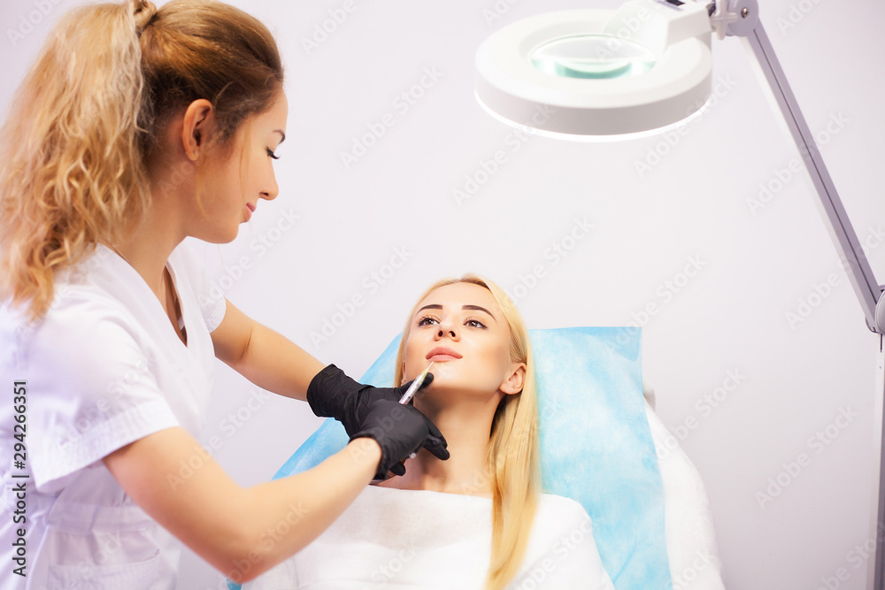 Fototapeta premium Lip Augmentation In Cosmetology Clinic. Beautiful Woman Getting Beauty Injection For Lips